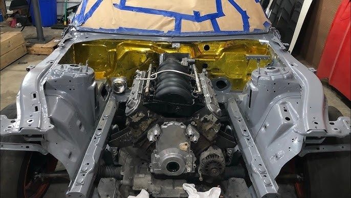 Freigelegter Motorraum mit V8-Motor und goldener Hitzeschutzfolie