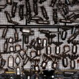 Viele gebrauchte Abgaskatalysatoren und Krümmer auf einem Metallgitter