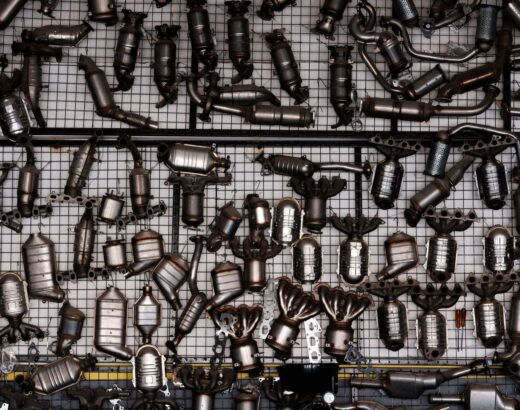 Viele gebrauchte Abgaskatalysatoren und Krümmer auf einem Metallgitter