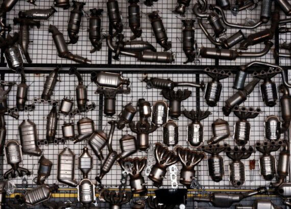 Viele gebrauchte Abgaskatalysatoren und Krümmer auf einem Metallgitter