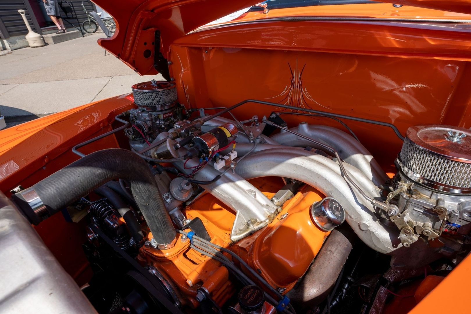 Orangefarbener V8-Motor mit sichtbaren Ansaug- und Abgaskrümmern